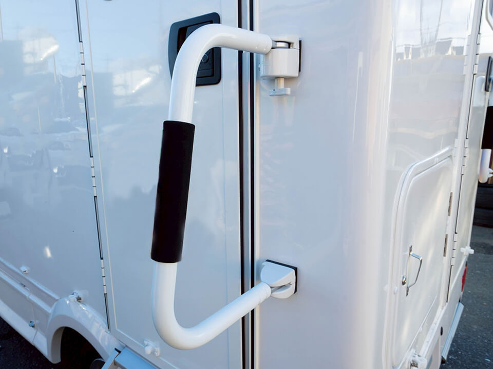 トイレカーのドア横に設置された頑丈な白い手すり
