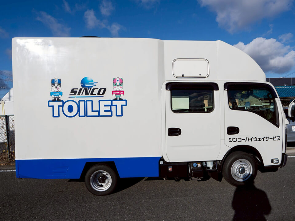 シェル部分と運転席横ドアにラッピングが施された中型トラックサイズのトイレカー